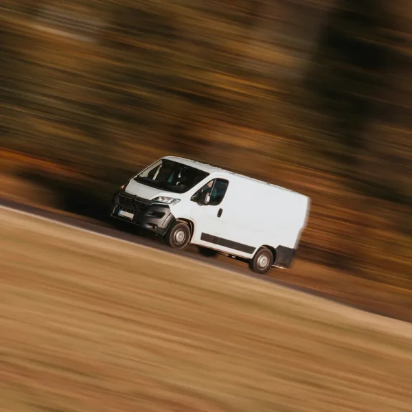 commercial-van2024-1 a white van driving on a road